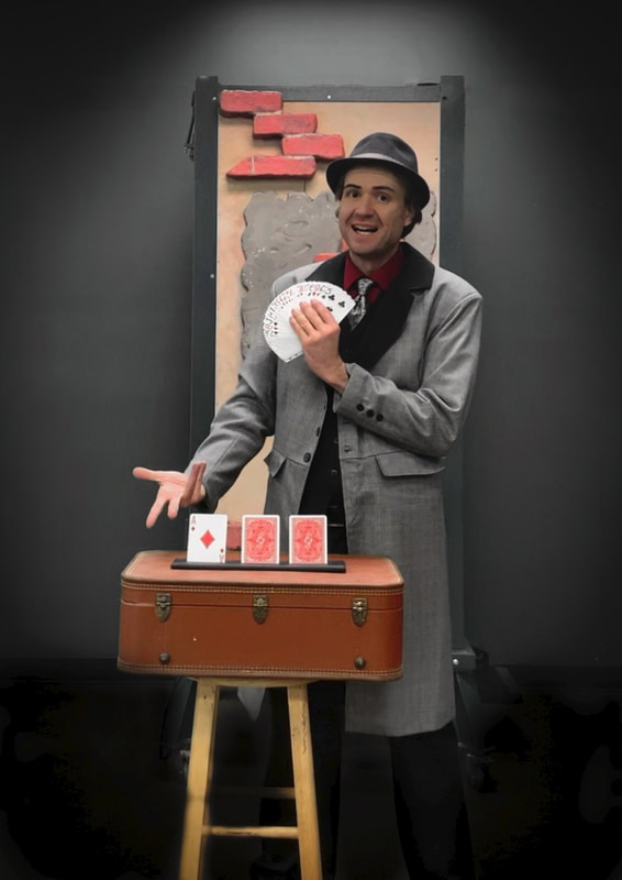 Magician with playing cards and a vintage suitcase. 